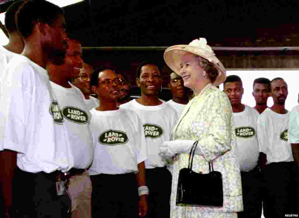 Britain's Queen Elizabeth II chats with workers at the Landrover factory in the north-west of Pretoria March 24, 1995. The Queen is on a six-day state visit to South Africa