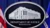 Logo dari Departemen Kehakiman AS terpasang pada podium di ruang pengarahan kantor departemen tersebut di Washington, pada 24 Januari 2023. (Foto: Reuters/Kevin Lamarque)