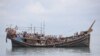 Pengungsi Rohingya yang baru tiba terdampar di perahu karena masyarakat sekitar memutuskan untuk tidak mengizinkan mereka mendarat setelah menyediakan air dan makanan di Pineung, Aceh pada 16 November 2023. (Foto: AFP)