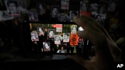 FILE - Activists display photos of journalists who have been killed in Mexico during a protest in Mexico City, July 10, 2023.