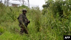 FILE - An M23 rebel looks on in Kibumba in the eastern Democratic Republic of the Congo, Dec. 23, 2022.