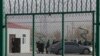 FILE - Residents line up inside the Artux City Vocational Skills Education Training Service Center, which had been revealed by leaked documents to be a forced indoctrination camp in western China's Xinjiang region, Dec. 3, 2018.