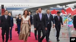 Presiden Suriah Bashar Assad, kanan tengah, dan ibu negara Asma Assad tiba di Hangzhou, China, pada 21 September 2023. (Foto: via AP)