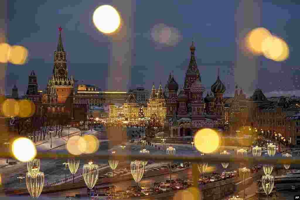 The Spasskaya Tower, Red Square, the GUM department store and the St. Basil's Cathedral are decorated for the New Year and Christmas holidays, as seen though a window of the Hotel Baltschug Kempinski Moscow, in Moscow, Russia.