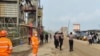 Sejumlah polisi dan pekerja berjaga di dekat lokasi ledakan tungku smelter di PT Indonesia Tsingshan Stainless Steel di Morowali, Sulawesi Tengah, pada 24 Desember 2023. (Foto: AP)
