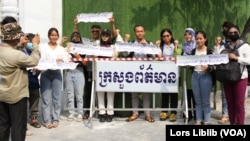 យុវជនមួយក្រុម លើកបដា នៅខាងមុខក្រសួងព័ត៌មាន ក្នុងរាជធានីភ្នំពេញ នៅពេលពួកគេដាក់ញត្តិស្នើសុំក្រសួងព័ត៌មានឱ្យបើកស្ថាប័នវីអូឌី និងសា្ថប័នសារព័ត៌មានឯករាជ្យផ្សេងឡើងវិញ កាលពីថ្ងៃទី៣១ ខែមីនា ឆ្នាំ២០២៣។ (លាស់ លីបលីប/វីអូអេ)