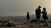 FILE - Tourists visit the Filopappou Hill, as Greece is hit by high temperatures and Saharan dust due to southern winds, in Athens, Greece, April 2, 2024.