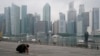 Seorang pria sedang tidur siang saat kawasan pusat bisnis diselimuti kabut di Singapura, pada 23 September 2019. (Foto: AP)