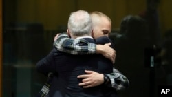 Ethan Elder, left, father of Finnegan Lee Elder, hugs his son at the end of a hearing for the appeals trial in which Finnegan is facing murder charges for killing Italian Carabinieri paramilitary police officer Mario Cerciello Rega, in Rome, July 3, 2024.