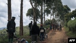 Sejumlah warga sipil tampak melarikan diri dari pertemuran yang terjadi di saat pasukan bersenjata Kongo berjaga di selatan dari area Kanyabayonga di provinsi Kivu Utara, pada 14 Mei 2024. (Foto: AFP/Alexis Hugut)