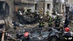 Petugas pemadam kebakaran berupaya memadamkan api di gedung apartemen yang hancur setelah serangan Rusia di Kyiv, Ukraina, Selasa, 2 Januari 2024. (AP/Efrem Lukatsky)