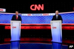 Presiden Joe Biden, kanan, dan calon presiden dari Partai Republik mantan Presiden Donald Trump, kiri, berdiri saat istirahat dalam debat presiden yang diselenggarakan oleh CNN di Atlanta, Georgia, 27 Juni 2024. (Foto: AP)