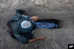 Avganistanac sahranjuje svog unuka koji je poginuo u zemljotresu u pokrajini Herat, Avganistan, 9. oktobra 2023.
