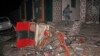 FILE - A man walks past a destroyed vehicle at the scene of a blast at a popular restaurant in the capital Mogadishu, Somalia, March 5, 2021. Police said at least 10 people were killed and more than 30 wounded. 