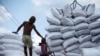 Seorang buruh berdiri di dekat karung-karung pupuk di Pelabuhan Sunda Kelapa, Jakarta. (Foto: REUTERS/Beawiharta)