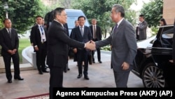 รัฐมนตรีต่างประเทศจีน หวัง อี้ ได้รับการต้อนรับจากรัฐมนตรีต่างประเทศกัมพูชา ที่กรุงพนมเปญ กัมพูชา เมื่อ 21 เม.ย. 2024 ตามภาพที่เผยแพร่โดย Agence Kampuchea Press (AKP) (AKP via AP)