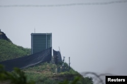 10일 한국 파주의 비무장지대의 한국 군 초소에서 2018년에 확성기가 해체되었던 군사 시설(그린 박스) 옆에서 한국군인들이 근무하고 있다.