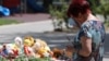 A woman reacts at a makeshift memorial to victims of what Russian authorities say was a Ukrainian missile strike, in Sevastopol, Russian-occupied Crimea, June 24, 2024. 