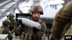 A Ukrainian artilleryman of the Aidar battalion holds an artillery shell on a front line position near Bakhmut, Donetsk region, on April 22, 2023.
