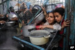 Warga Palestina antre untuk menerima makanan gratis di kamp pengungsi Jabaliya di Jalur Gaza, 18 Maret 2024. (Foto: AP)