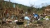 Orang-orang melihat puing-puing setelah serangan militer di sebuah kamp pengungsi di dekat Kota Laiza di Myanmar utara pada 11 Oktober 2023, dua hari setelah serangan yang menewaskan 29 orang dan melukai puluhan lainnya. (Foto: AFP)