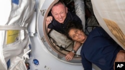 FILE - In this photo provided by NASA, Boeing Crew Flight Test astronauts Butch Wilmore, left, and Suni Williams pose for a portrait inside the vestibule between the forward port on the ISS's Harmony module and Boeing's Starliner spacecraft on June 13, 2024.