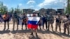Yevgeny Prigozhin (depan), kepala perusahaan militer swasta grup "Wagner" berbicara sambil memegang bendera Rusia di depan tentaranya di Bakhmut, Ukraina.