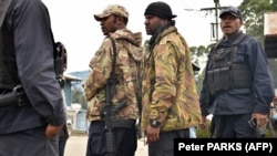 Polisi bersenjata Papua Nugini bersiap untuk berpatroli. (Foto: AFP/Peter PARKS)