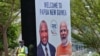 Seorang petugas keamanan berdiri di samping spanduk yang menampilkan Perdana Menteri Papua Nugini (kiri) dan Perdana Menteri India Narendra Modi di ibu kota Port Moresby, Papua Nugini, 18 Mei 2023. 