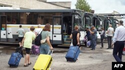 This handout photograph taken and released by the Government of Kursk region of Russia on Aug. 9, 2024, shows women and children being evacuated from the town of Rylsk in Kursk region. 