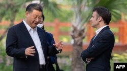 Архівне фото: президент Китаю Сі Цзіньпін і президент Франції Еммануель Макрон розмовляють під час відвідування саду резиденції губернатора Гуандуну в Гуанчжоу, Китай, 7 квітня 2023 року. Jacques WITT/POOL/AFP