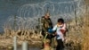 FILE - Migrants are taken into custody by officials at the Texas-Mexico border, in Eagle Pass, Texas, Jan. 3, 2024.