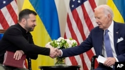 Presiden AS Joe Biden berjabat tangan dengan Presiden Ukraina Volodymyr Zelenskyy di Paris, 7 Juni 2024. (Foto: AP)