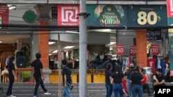 Karyawan toko Ramayana di Denpasar, Bali, menunggu di luar gedung setelah diguncang gempa berkekuatan 7,0 SR yang dilaporkan berpusat di laut utara pulau Jawa, 14 April 2023.