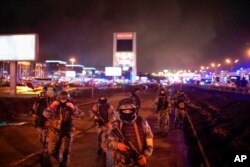 FILE - Russian guardsmen secure an area at the Crocus City Hall on the edge of Moscow, March 23, 2024. Images of suspects in a mass shooting at the hall showed them apparently being brutalized by security forces — with no rebuke from authorities.
