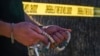 Seorang warga tampak berdoa dengan rosario di lokasi pembunuhan Uskup David O’Connell di Hacienda Heights, California, pada 19 Februari 2023. (Foto: AP/Damian Dovarganes)