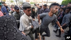 Warga Palestina mengangkut warga lainnya yang terluka akibat serangan udara Israel di dekat Rumah Sakit Al-Aqsa di Deir al Balah, Jalur Gaza, pada 31 Maret 2024. (Foto: AP/Abdel Kareem Hana)