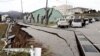 Orang-orang berdiri di dekat retakan besar di trotoar setelah mengungsi ke jalan di kota Wajima, prefektur Ishikawa pada 1 Januari 2024, setelah gempa bumi besar berkekuatan 7,5 melanda wilayah Noto di prefektur Ishikawa. (Foto: AFP)
