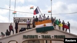 Para pengunjuk rasa memegang bendera Niger dan Rusia untuk mendukung tentara pembangkang di ibu kota Niamey, Niger, 3 Agustus 2023. (REUTERS/Mahamadou Hamidou)