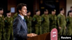 FILE - Canada's Prime Minister Justin Trudeau announces that Canada will send more military equipment and impose additional sanctions on Russian officials on the one-year anniversary of Russia's invasion of Ukraine, at Fort York Armoury in Toronto, Canada, Feb. 24, 2023.