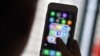 FILE - A woman looks at social networking apps Facebook, Instagram, Snapchat, Whatsapp, Twitter, Messenger and Linkedin on a smartphone, March 22, 2018.