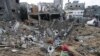 Beberapa warga Palestina memeriksa kehancuran setelah serangan udara Israel di sebuah bangunan permukiman di kota Deir al Balah, Jalur Gaza, 14 Januari 2024.