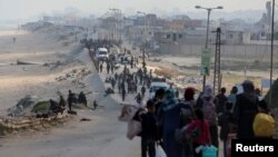 FILE - Warga Palestina, yang mengungsi akibat serangan militer Israel di Gaza selatan, berusaha untuk kembali ke rumah mereka di Gaza utara melalui pos pemeriksaan Israel, seperti yang terlihat dari Jalur Gaza tengah, 15 April 2024.