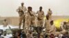 FILE - Sudanese soldiers from the Rapid Support Forces stand on their vehicle during a military-backed rally in Mayo district, Sudan, on June 29, 2019. 