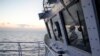 FILE - A member of the Philippine Coast Guard watches from the bridge of the BRP Malabrigo as they patrol and resupply troops at Philippine-occupied areas in the South China Sea, Apr. 19, 2023.