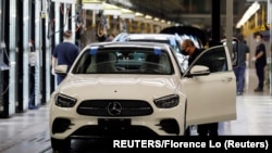 Para pekerja sedang memeriksa mobil Mercedes-Benz di pabrik Beijing Benz Automotive, perusahaan patungan BAIC Motor dan produsen mobil Jerman Mercedes-Benz, di Beijing, China, 17 Februari 2022. (Foto: Florence Lo/Reuters)