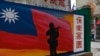 Seorang turis (kanan) berjalan melewati mural yang dilukis di dinding Kepulauan Kinmen Taiwan, yang terletak hanya 3,2 km dari pantai daratan China. (Foto: AFP)