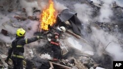 Фото для ілюстрації: рятувальники на руїнах будинку, зруйнованого в Харкові під час атак Росії, 23 січня 2024 року 