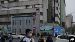 ປະ​ຊາ​ຊົນ​ຍ່າງ​ກາຍ​ສະ​ຖາ​ນີ​ຕຳຫຼວດ​ໃນ​ນະ​ຄອນ ອູ​ຣຸມ​ຈີ, ເມືອງ​ເອກ​ຂອງ​ພາກ​ພື້ນ ຊິນ​ຈຽງ, 21 ເມ​ສາ 2021.