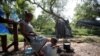 Pencari suaka asal Venzuela, Alejandra Pena, 34, memandikan anaknya Natanael, 1, di sebuah ember plastik di samping tenda mereka di kamp pengungsi di Matamoros, Meksiko, pada 20 Juni 2023. (Foto: Reuters/Daniel Becerril)
